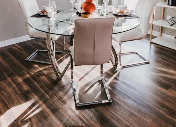 a dining room with a glass table and chairs
