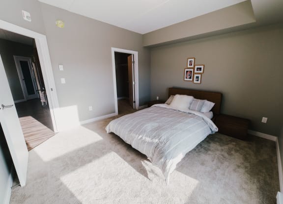 a bedroom with a bed and a carpeted floor