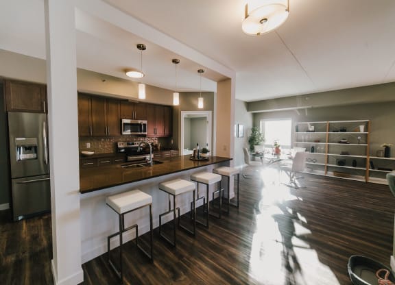 a kitchen and living room with a bar and stools