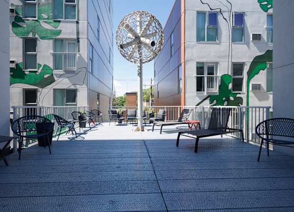 A patio with a table and chairs and a sculpture in the middle.