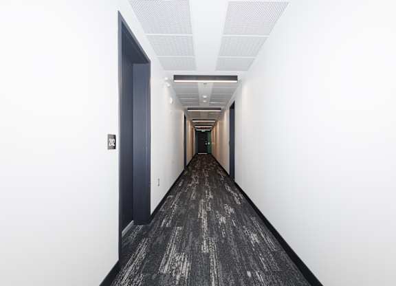 A long hallway with a black floor and white walls.