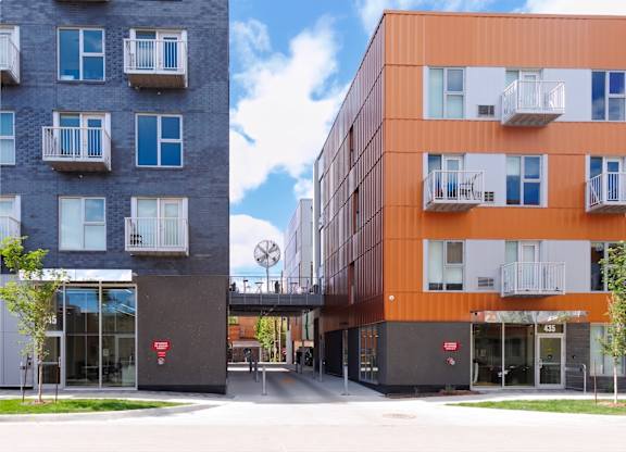 Two modern apartment buildings with balconies and doors.