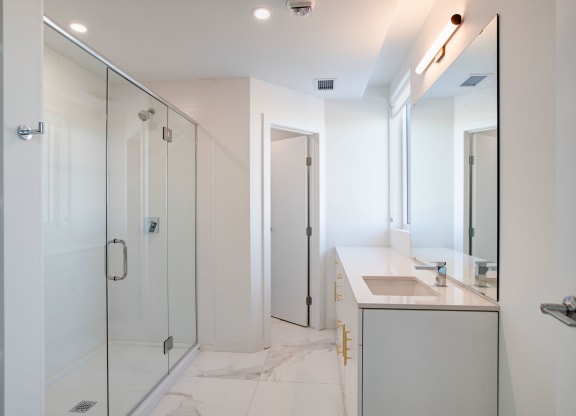 a white bathroom with a shower and a sink