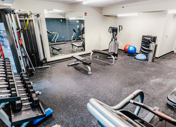 a gym with cardio machines and weights on the floor
