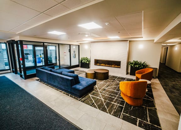a lobby with couches and chairs and a fireplace