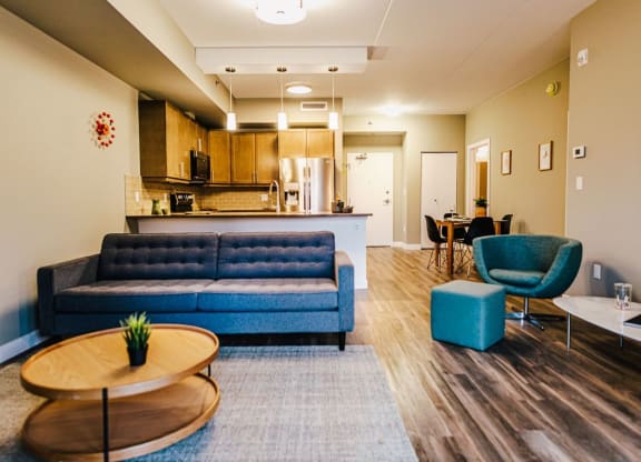 a living room and kitchen with blue couches and chairs