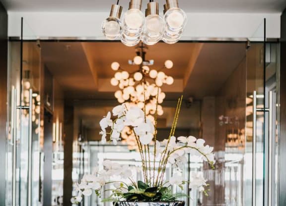 a white table with a flower arrangement in a room with glass doors