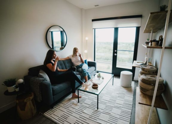 two women sitting on a couch in a living room