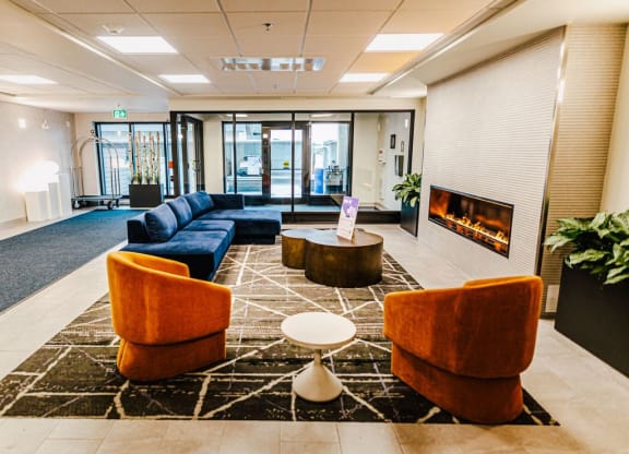 a lobby with couches and chairs and a fireplace