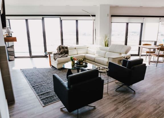 a living room with a white couch and two black chairs
