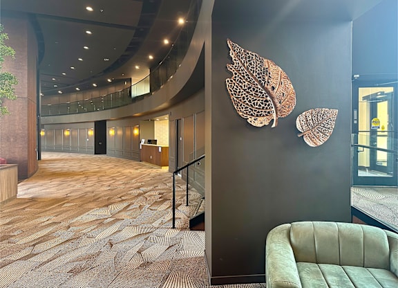 a lobby with a couch and a wall with two leaves on it