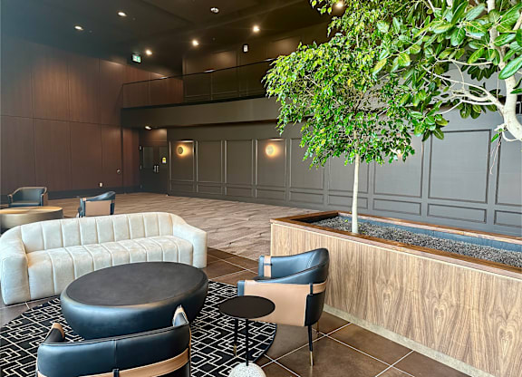 a lobby with couches and chairs and a tree
