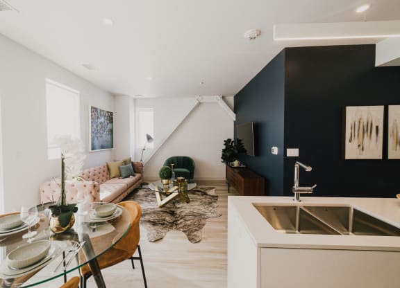a living room and dining room with a sink and a table