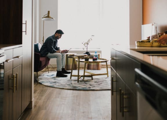 a man sitting in a chair at a table in a living room