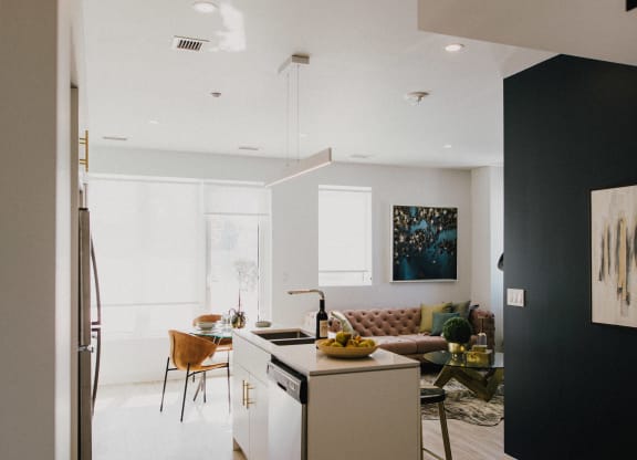 a kitchen and living room with white walls and wooden floors