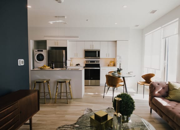 a living room with a kitchen and a table with chairs