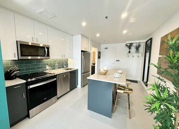 A kitchen with a black stove top oven and a black microwave.