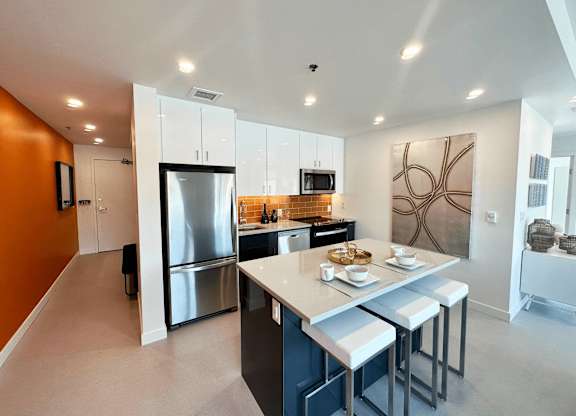 A modern kitchen with a large island and stainless steel appliances.
