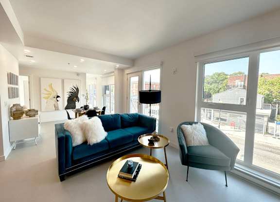 A living room with a blue couch and a gold coffee table.