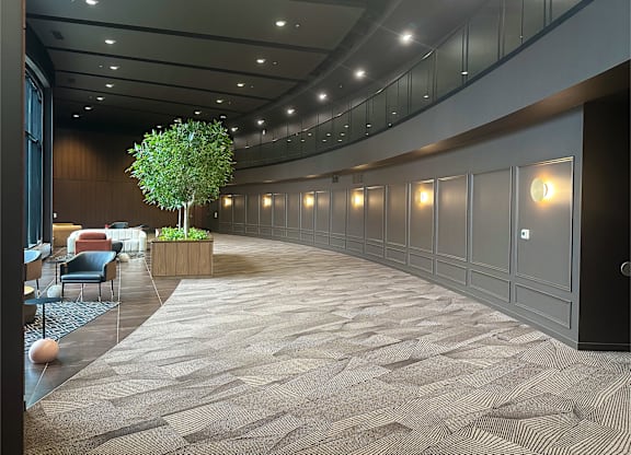 A long hallway with a tree in a planter in the middle.