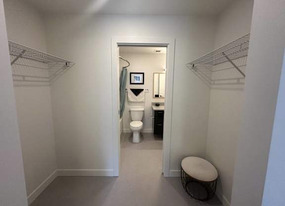 A small bathroom with a toilet, sink, and a mirror.