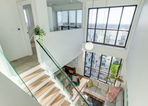 a view of the living room from the top of the stairs in a modern home