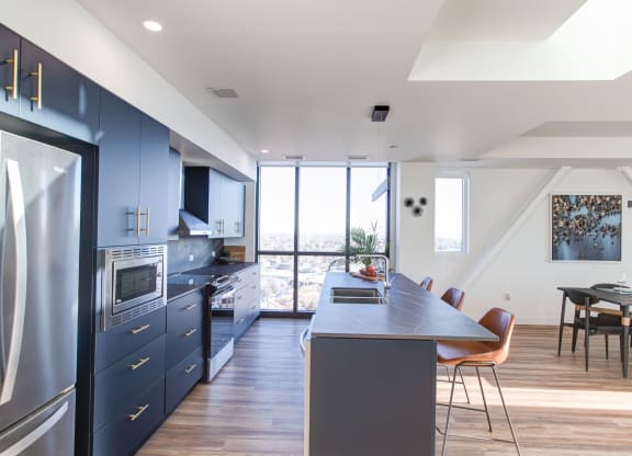 a large kitchen with blue cabinets and a table and chairs