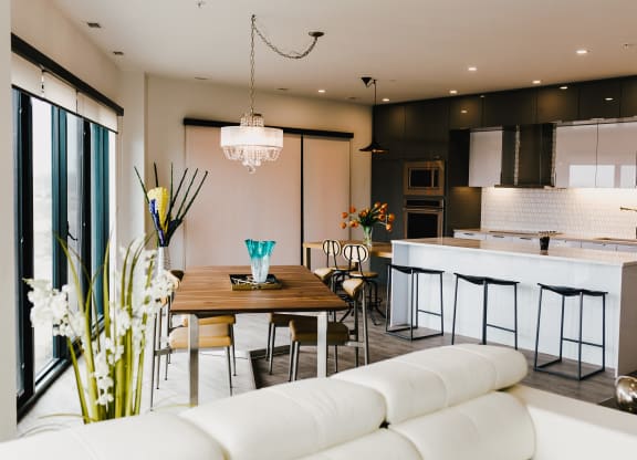 a living room and kitchen with white furniture and a wooden table
