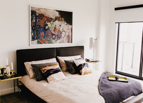 a bedroom with a bed and a painting on the wall