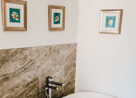 a large white bath tub in a bathroom with a shower