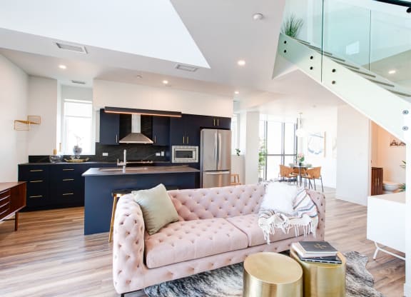 a living room and kitchen with a pink couch