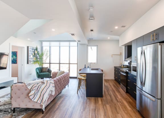 a kitchen and living room with a stainless steel refrigerator