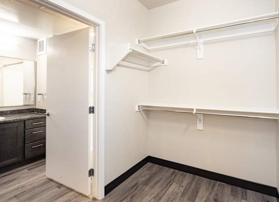 A white closet with a shelf and a mirror.