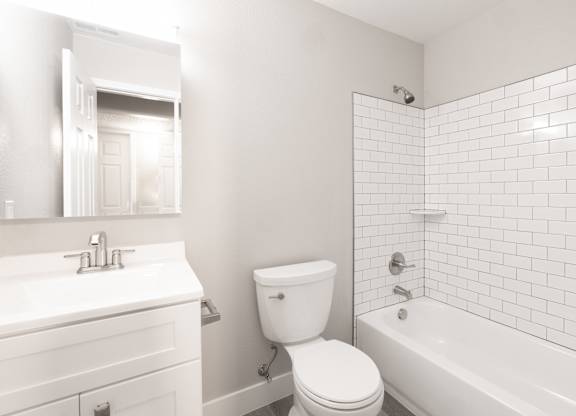 A white bathroom with a toilet, sink, and bathtub.