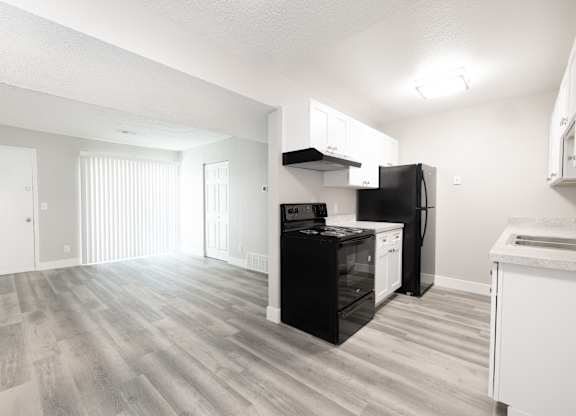 A kitchen with black appliances and white cabinets.