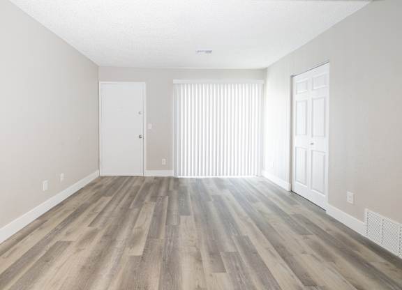 A room with wooden flooring and white walls.