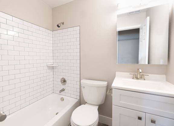 A white bathroom with a toilet, sink, and bathtub.