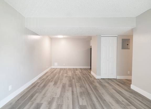 A room with wooden flooring and white walls.