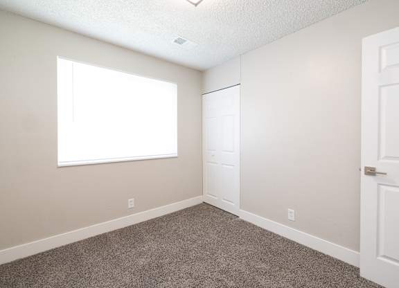 A room with a white door and a window.
