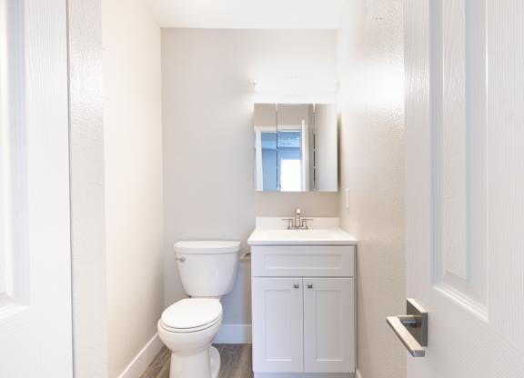 A white toilet and sink in a small bathroom.