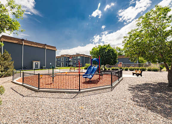 A playground with a swing set and a fenced area.