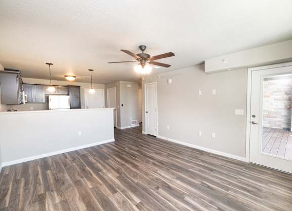 A room with a ceiling fan and wooden flooring.