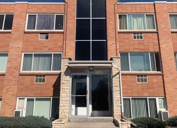 the front of a brick building with a clear blue sky