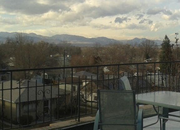 a balcony with a table and chairs and a view of the mountains