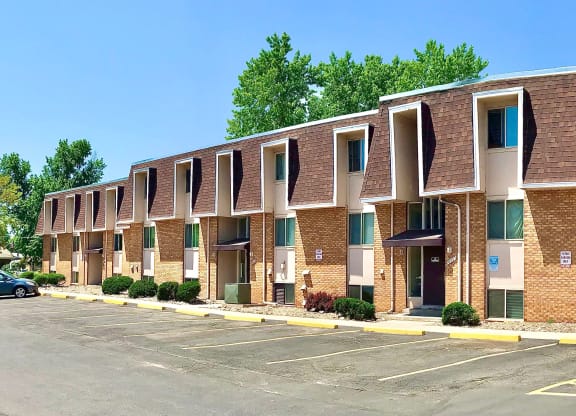 a row of brick apartment buildings in a parking lot