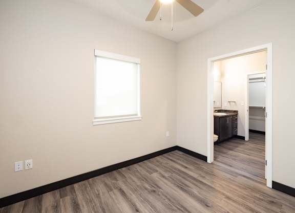 a living room with wood flooring and a ceiling fan