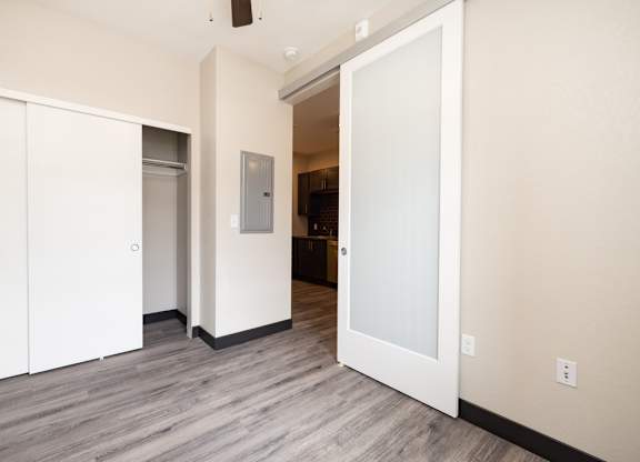 a view of a living room with white walls and wood floors