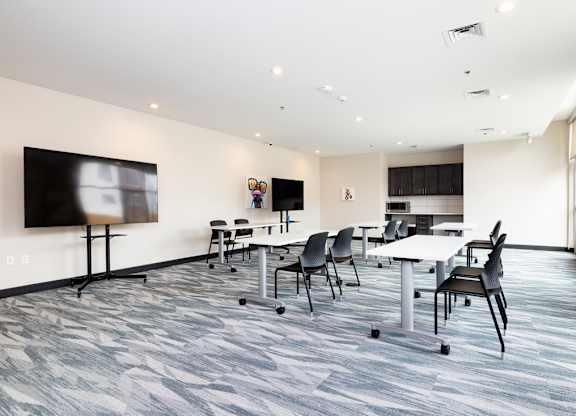 a conference room with tables and chairs and a tv