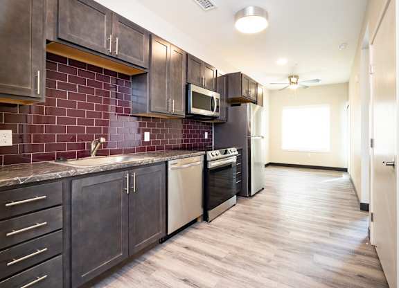 a kitchen with dark cabinets and a sink and a microwave
