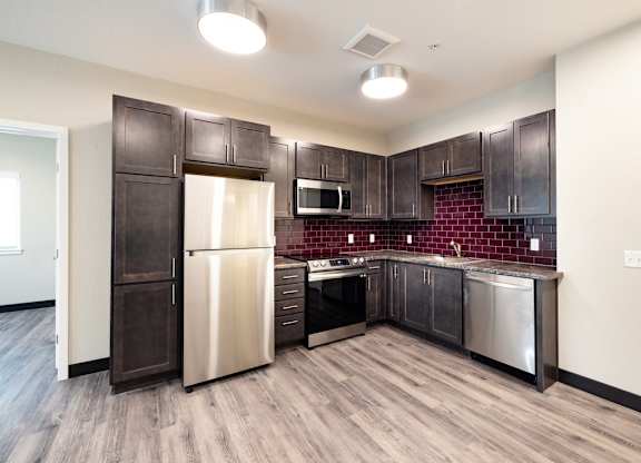 a kitchen with stainless steel appliances and dark wood cabinets
